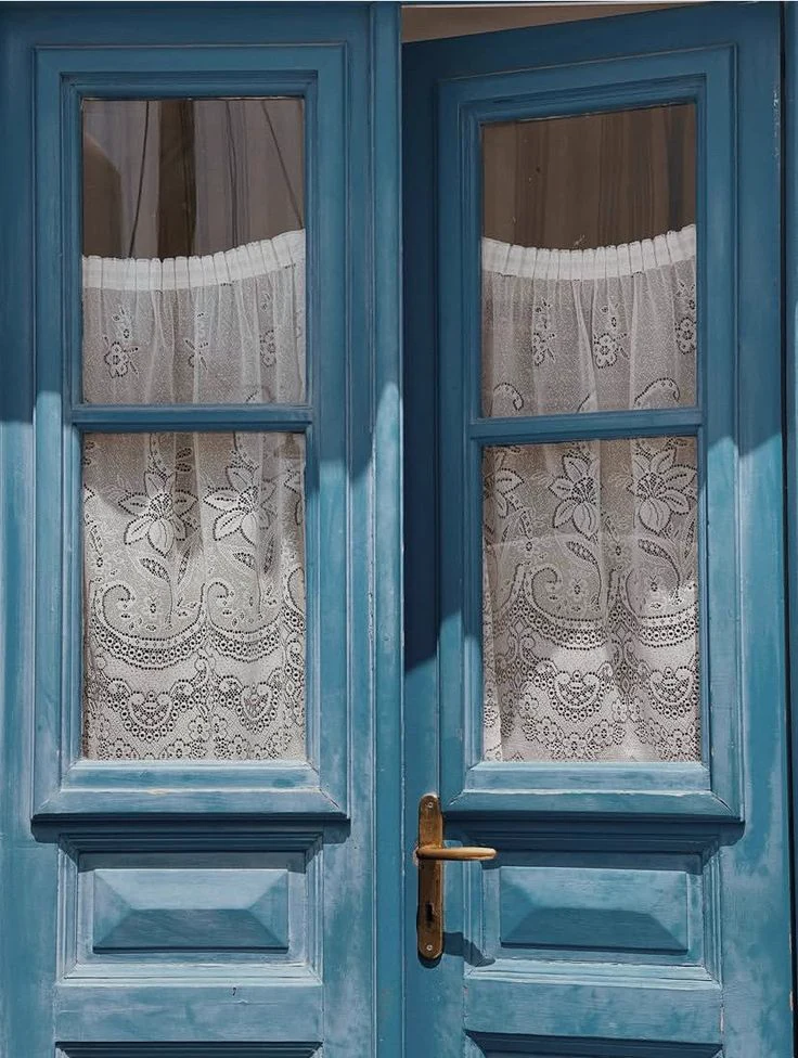 Puerta azul con encaje blanco, asociada a una estética cuidada y cercana.